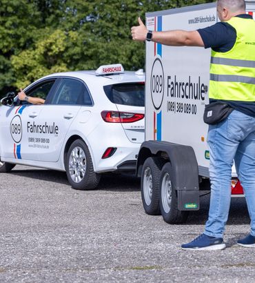 Fahrlehrer weist beim Rangieren mit Anhänger ein